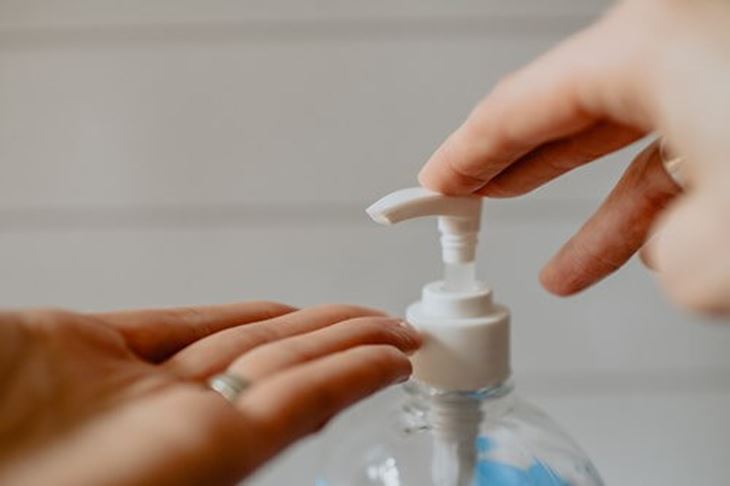 Woman using hand sanitizer from a pump bottle