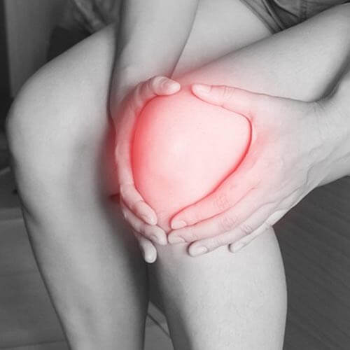 A person holding their knee with a red glow highlighting the injury